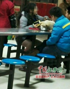 愛犬に学食の食事を与える中国人女子学生