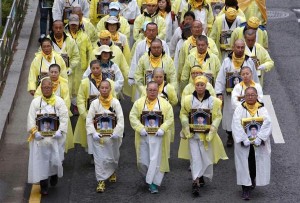 遺影をかかげて行進する遺族。沈船引き上げを約束したがさて・・・